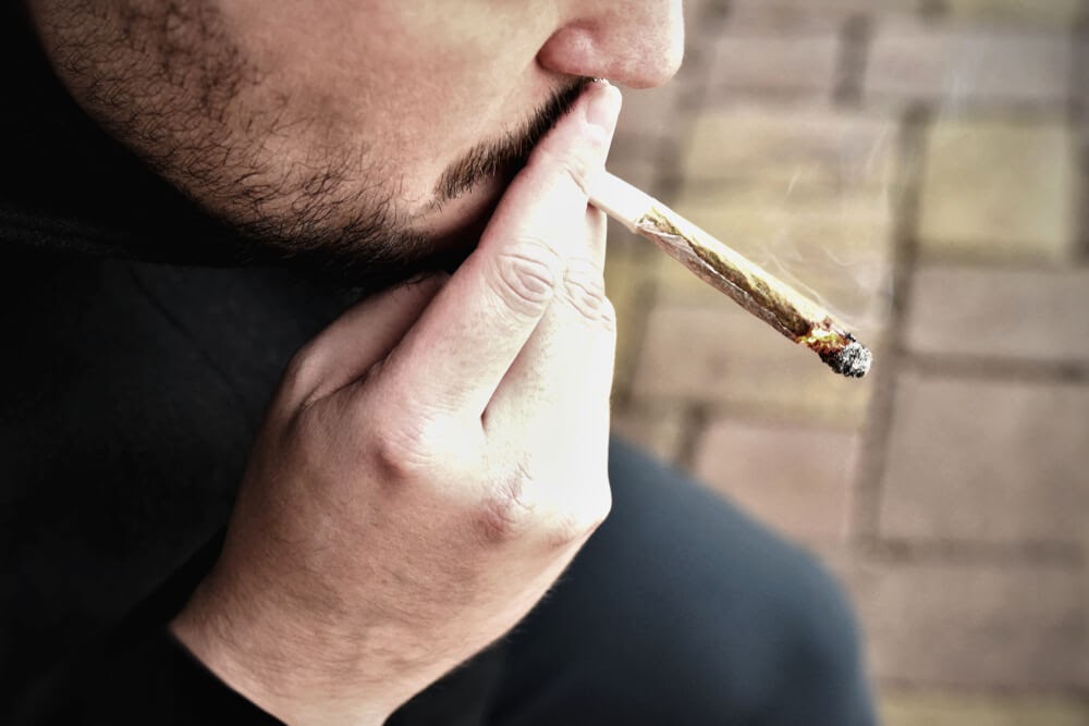 A marijuana addict smokes cannabis to satisfy their cravings.