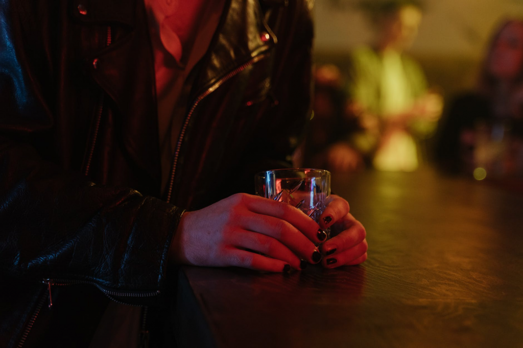 A woman consuming alcohol at a bar.